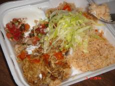 A hearty helpful of carnitas, served with rice and sour cream. ()