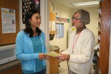 Nurse Jan Gersonde (left) gives information to Lili Ding (right) on swine flu. (Derrick Smith)