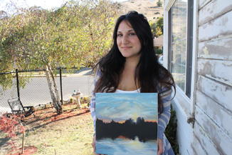 Skyline student Rachel Grgich holding one of her paintings. 