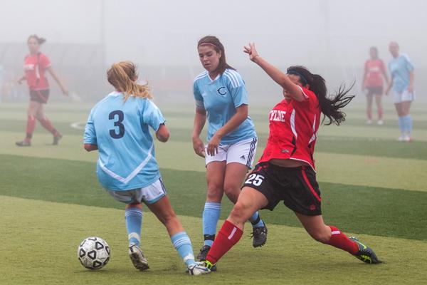 Forward Brooke Penner attempts to reach the ball behind two opponents. 