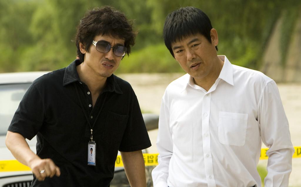 Detective Park (Jo Hie-Bong, left) and Prosecutor Song Jae-Pil (Song Dong-Il, right) talking at a crime scene. 