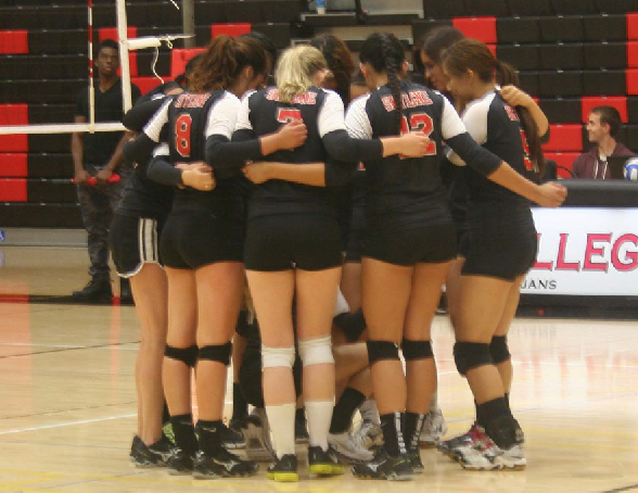 The Lady Trojans huddle after their victory.