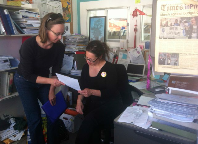 American Teacher Federation President, Alisa Messer, reviews paperwork with a collegue at City College of San Francisco