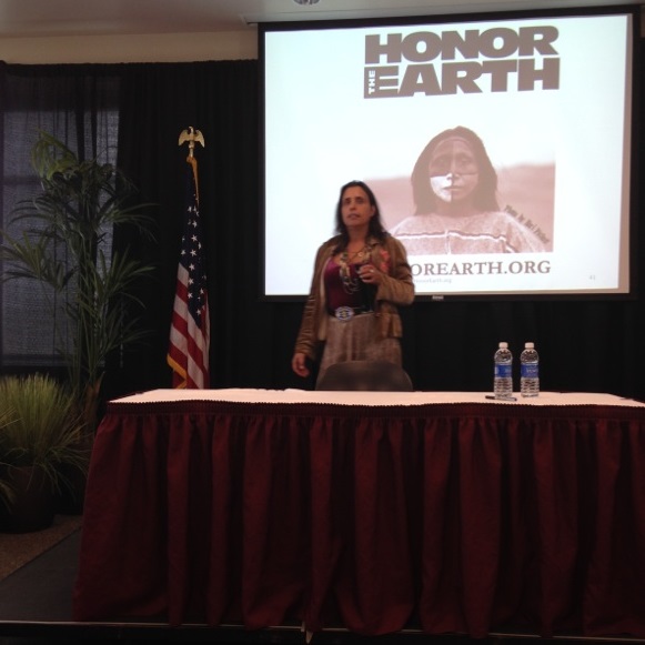 Speaker Winona LaDuke at the front of room, speaking during the event. 