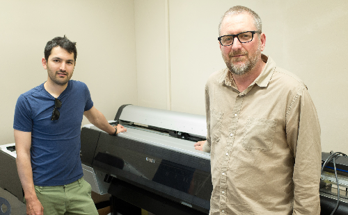 Professor Esfahani (left) in Professor Bridenbaugh’s (right) office standing in front of a large format digital printer that will be used in the new digital media lab on May 13, 2014. Both Professors will be in charge of operating the new lab.