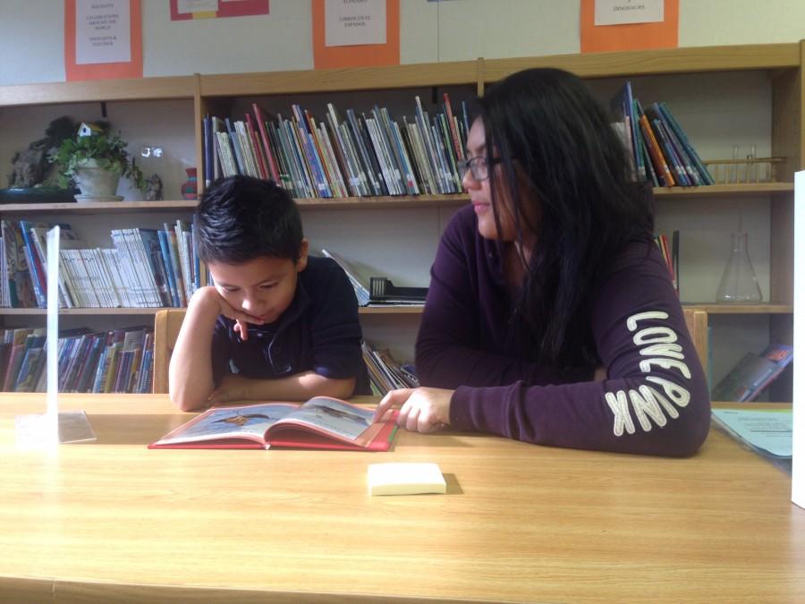 3rd grader Joseph Dominguez, and tutor Mariden Totantes reading together. 