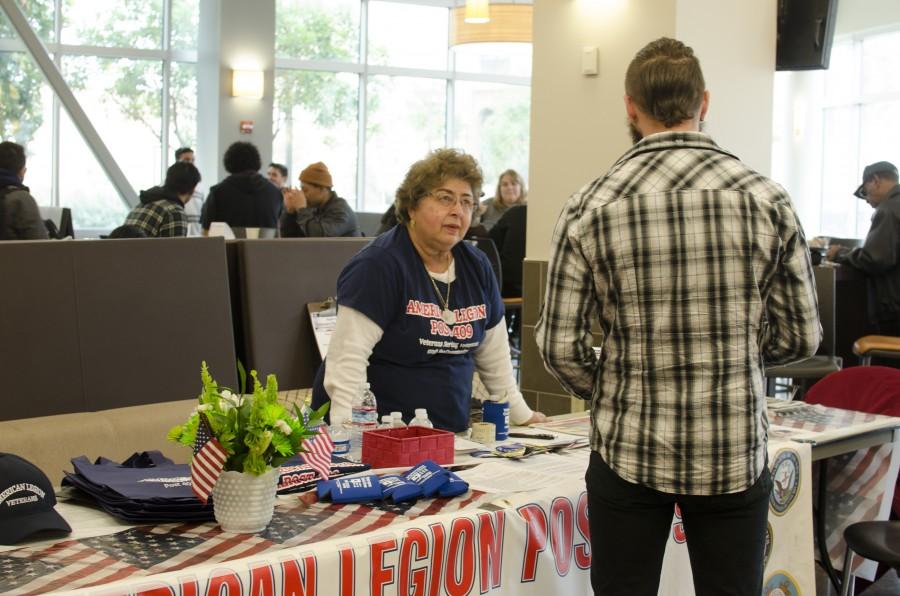 American Legion volunteer, Ana Garcia, talks to a Skyline College student about the non-profit organizations services and programs during the Veterans Resource Event in Skyline Colleges Fireside Dining Hall on Mar. 10, 2016.