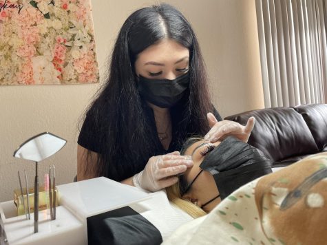 19-year-old business owner Kaylee Arriaga applies lashes to her client.