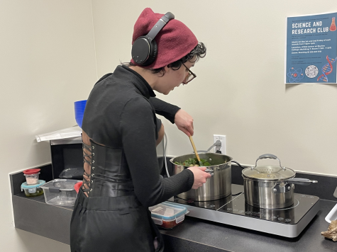 Club President Amanda Ratti stirs the pot after adding the greens to the dish. 
