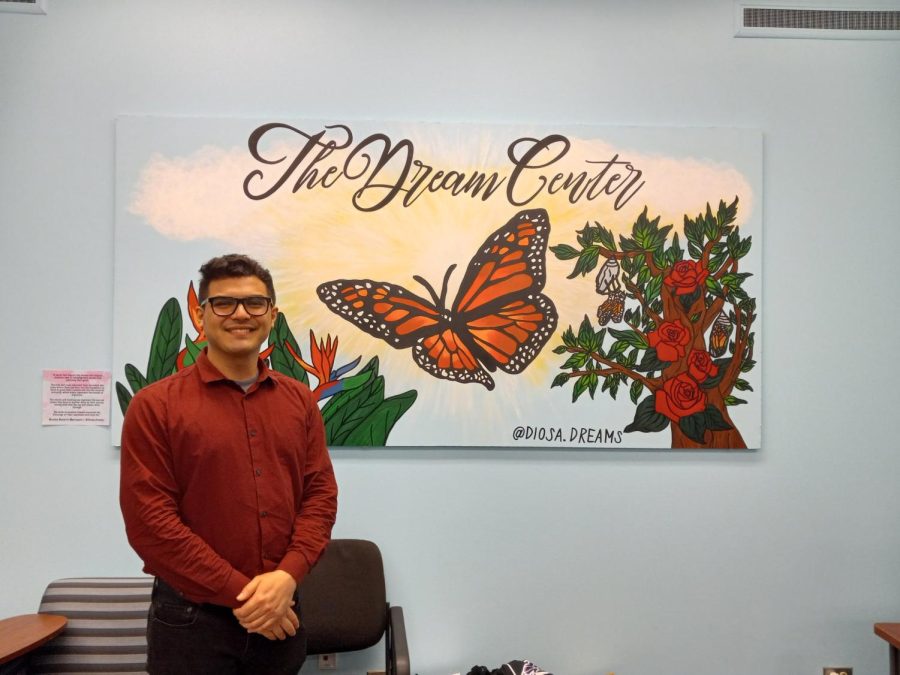 Veloso poses in front  of a mural in the Dream Center, where he is a student assistant