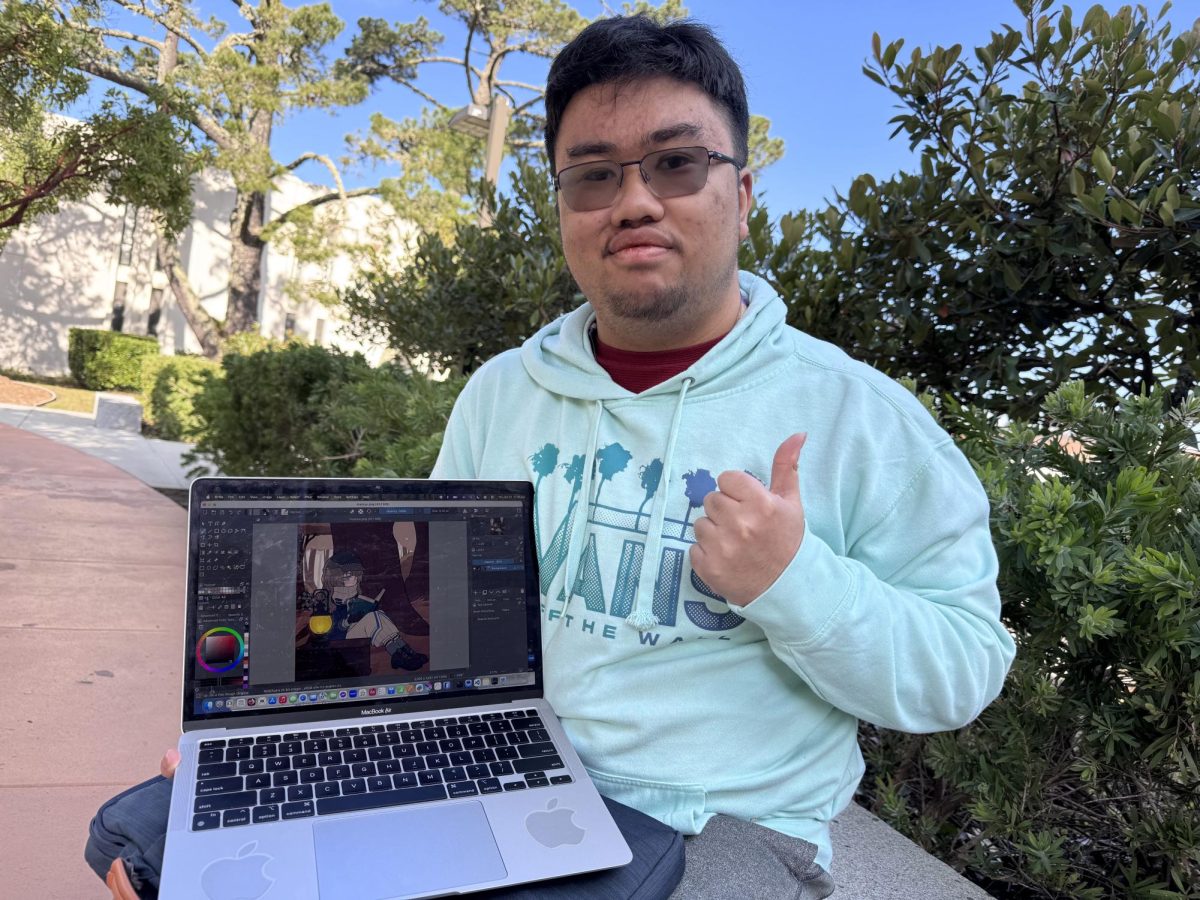 Andre Inobe, computer science major, poses with a drawing of Marcus from Reverse 1999.