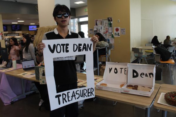 Freshman Skyline student Dean Quan wears his "Vote Dean," sunglasses and makeshift picture frame for students to take pictures in for his social media campaign.